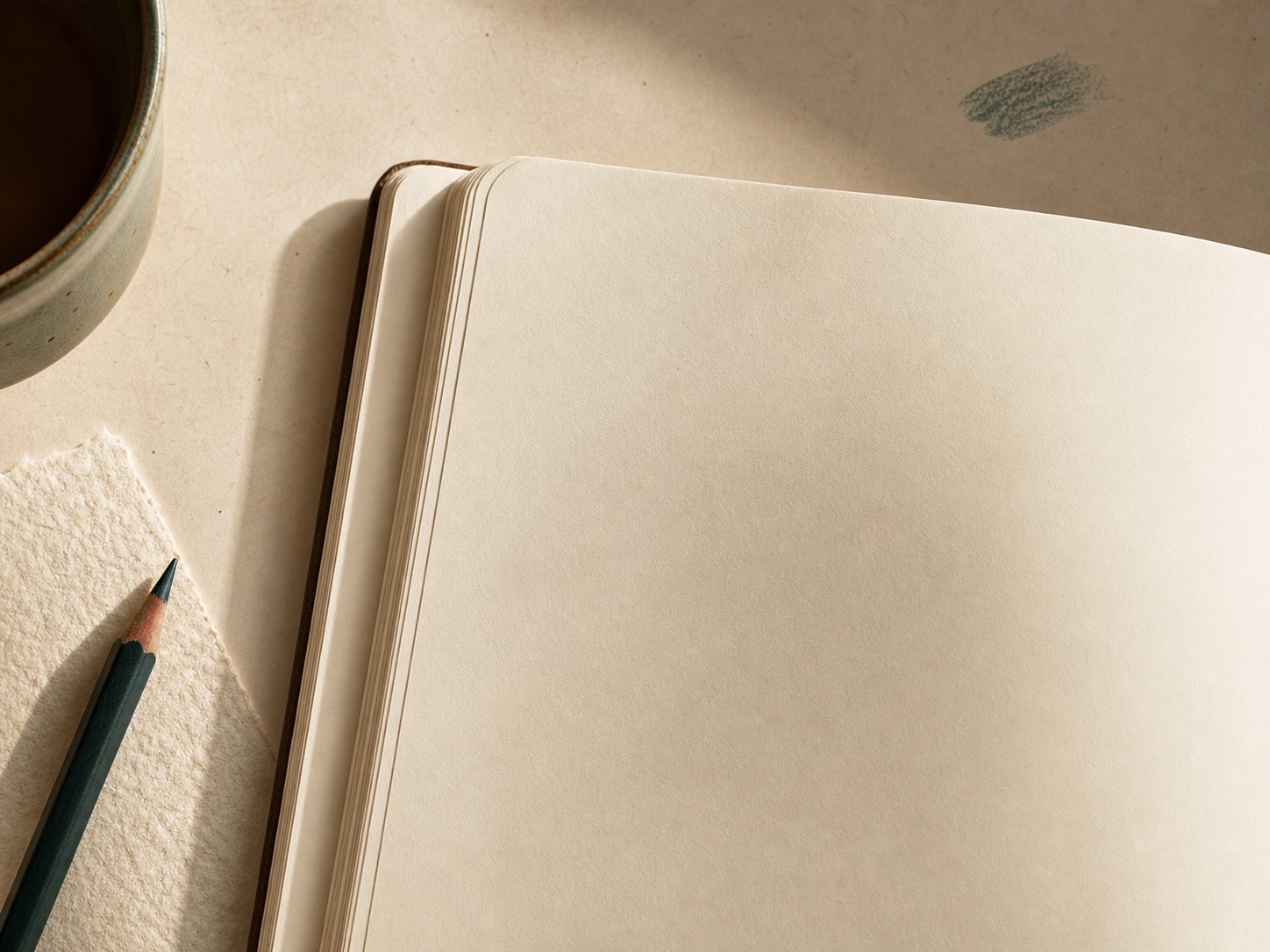 Blank cream journal page on a warm desk with pencil and ceramic cup